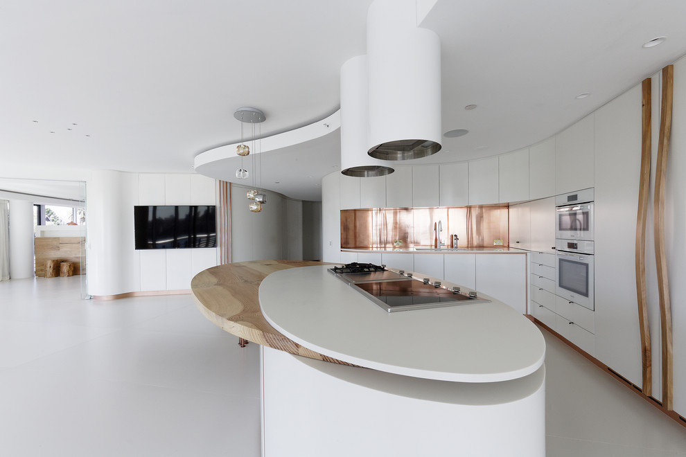 Inspiration for a large modern l-shaped ceramic tile and beige floor open concept kitchen remodel in Sydney with an undermount sink, flat-panel cabinets, white cabinets, solid surface countertops, metallic backsplash, metal backsplash, white appliances and an island
