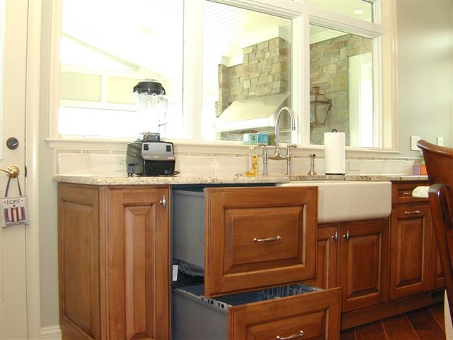 Foto på ett stort lantligt kök, med en rustik diskho, luckor med upphöjd panel, skåp i mörkt trä, granitbänkskiva, gult stänkskydd, stänkskydd i porslinskakel, integrerade vitvaror, mellanmörkt trägolv och en köksö