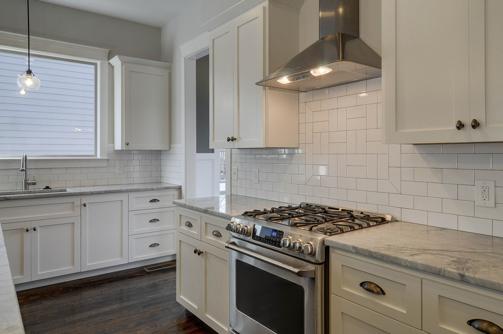 Mid-sized elegant single-wall dark wood floor and brown floor open concept kitchen photo in Nashville with an undermount sink, shaker cabinets, white cabinets, granite countertops, white backsplash, subway tile backsplash, stainless steel appliances, an island and gray countertops