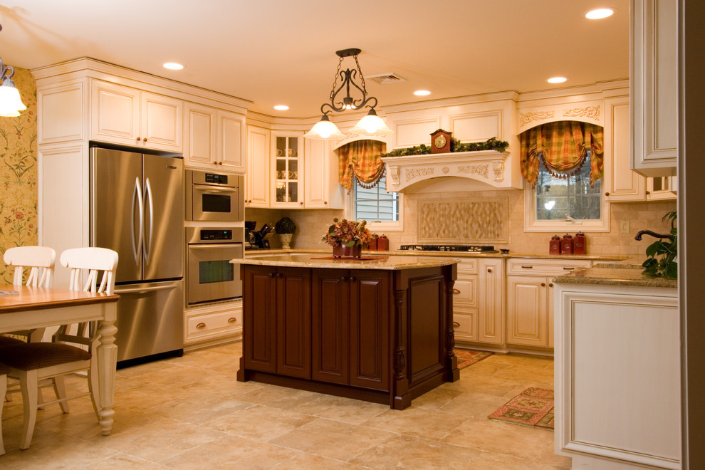 Ejemplo de cocina clásica con armarios con paneles con relieve, puertas de armario beige, salpicadero beige y electrodomésticos de acero inoxidable