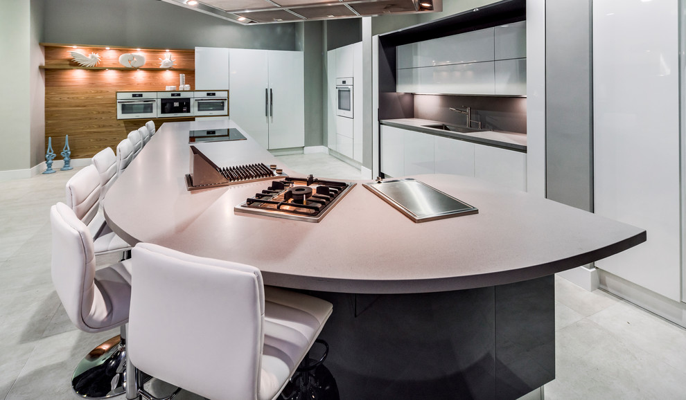 Eat-in kitchen - huge contemporary single-wall porcelain tile eat-in kitchen idea in San Francisco with a single-bowl sink, flat-panel cabinets, white cabinets, quartz countertops, gray backsplash, white appliances and an island
