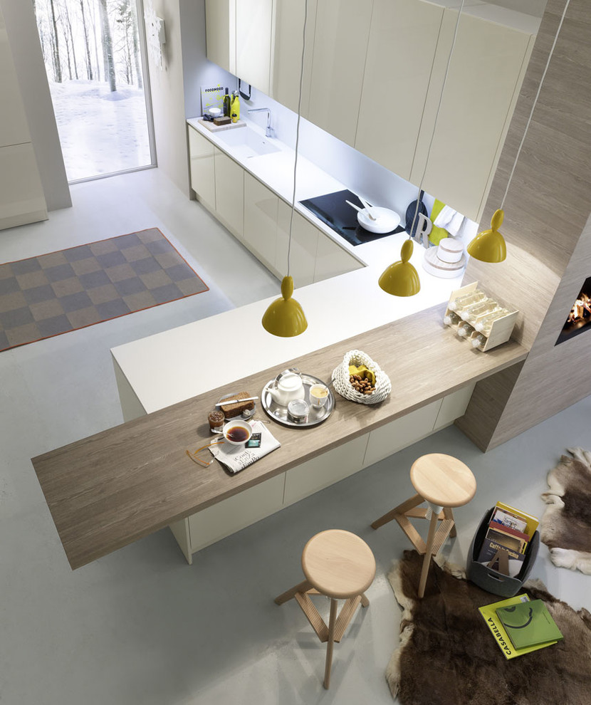 Imagen de cocina contemporánea de tamaño medio con armarios con paneles lisos, electrodomésticos negros, una isla, fregadero integrado y puertas de armario beige