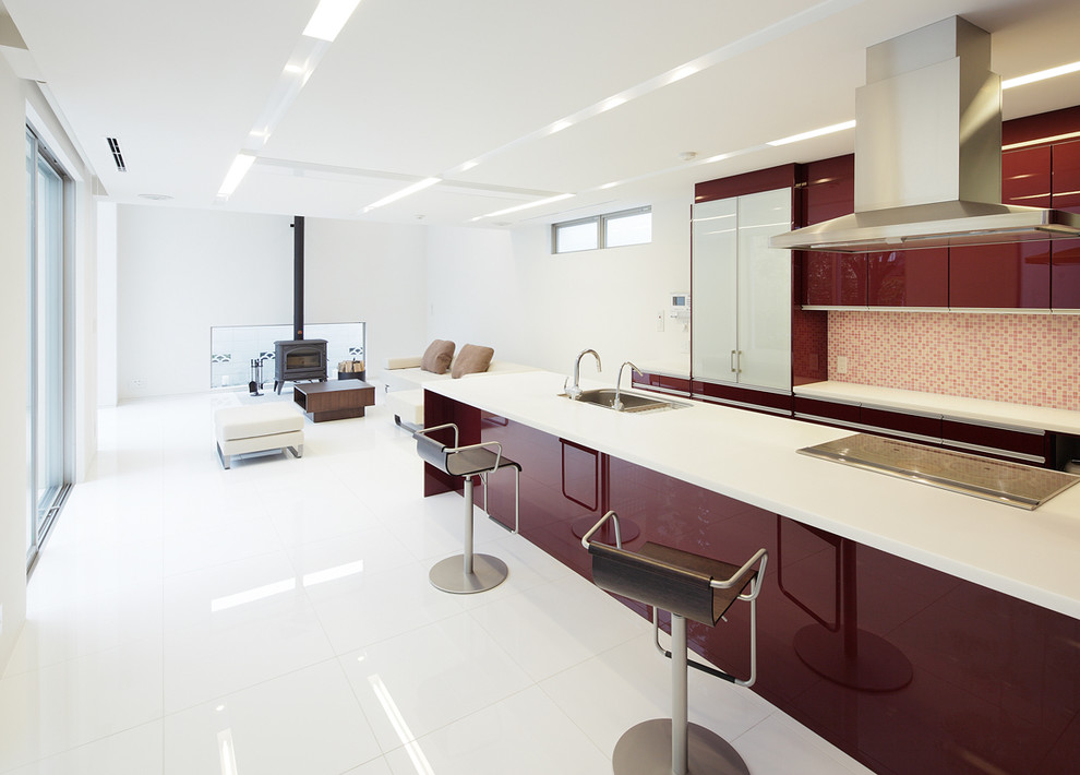 Exempel på ett modernt linjärt kök med öppen planlösning, med en enkel diskho, släta luckor, röda skåp, flerfärgad stänkskydd, en halv köksö och vitt golv
