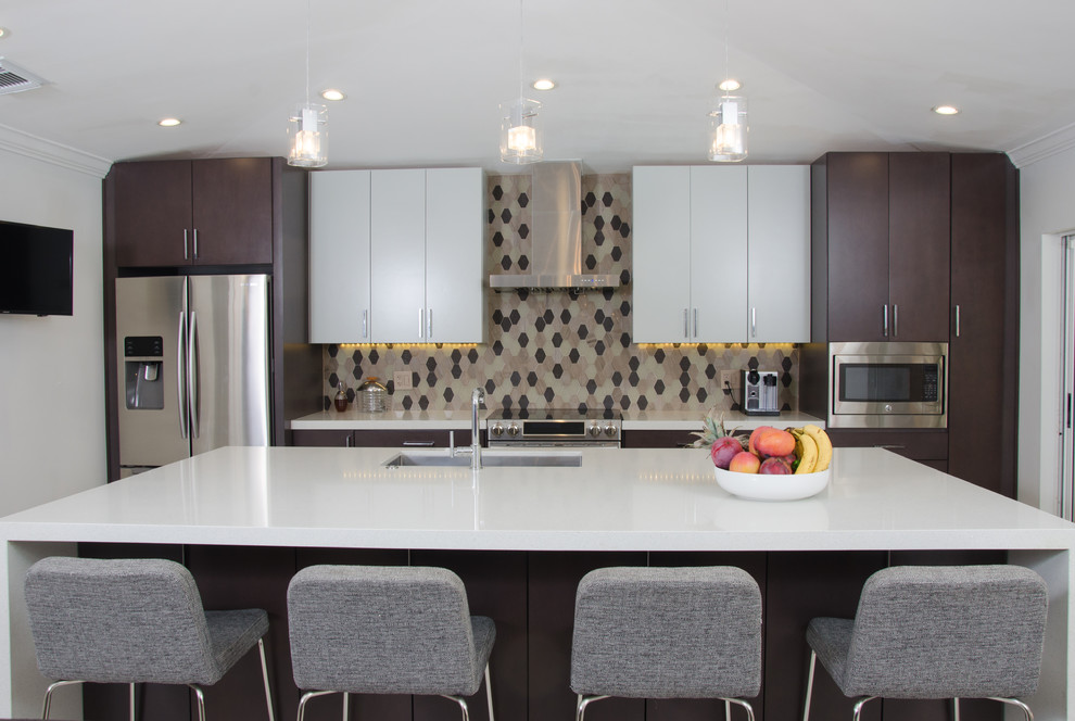 Modern inredning av ett stort kök, med en undermonterad diskho, släta luckor, grå skåp, bänkskiva i kvarts, brunt stänkskydd, stänkskydd i stenkakel, rostfria vitvaror, klinkergolv i porslin, en köksö och beiget golv