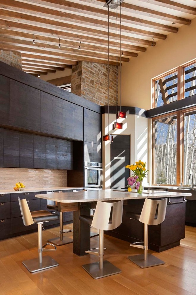 Moderne Wohnküche in U-Form mit Landhausspüle, flächenbündigen Schrankfronten, dunklen Holzschränken, Granit-Arbeitsplatte, Küchenrückwand in Beige, Rückwand aus Stäbchenfliesen und Küchengeräten aus Edelstahl in Denver