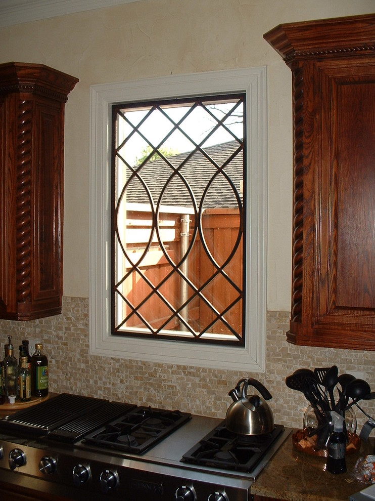 Exempel på ett mellanstort medelhavsstil kök, med luckor med infälld panel, skåp i mellenmörkt trä, granitbänkskiva, beige stänkskydd, stänkskydd i stickkakel och rostfria vitvaror