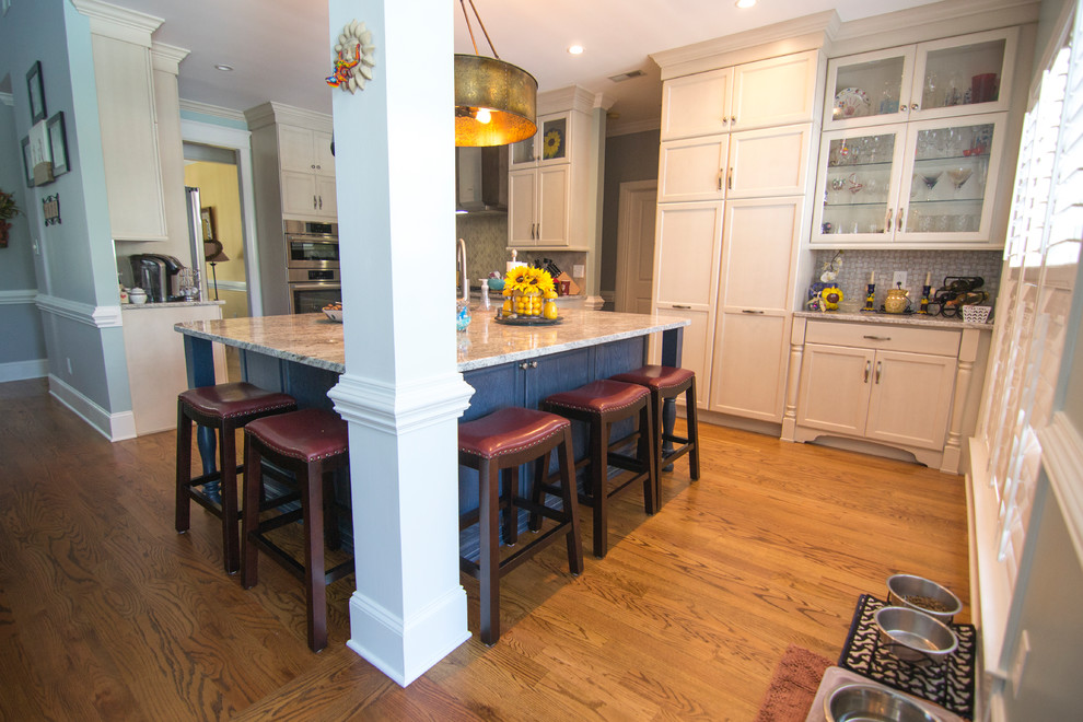 Exempel på ett stort modernt kök, med en undermonterad diskho, skåp i shakerstil, vita skåp, granitbänkskiva, grått stänkskydd, stänkskydd i mosaik, rostfria vitvaror, mellanmörkt trägolv, en köksö och brunt golv