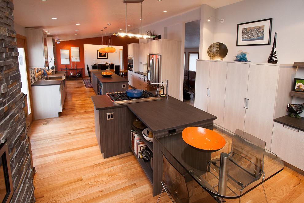 Geschlossene, Mittelgroße Moderne Küche mit flächenbündigen Schrankfronten, weißen Schränken, Mineralwerkstoff-Arbeitsplatte, dunklem Holzboden und braunem Boden in Boise