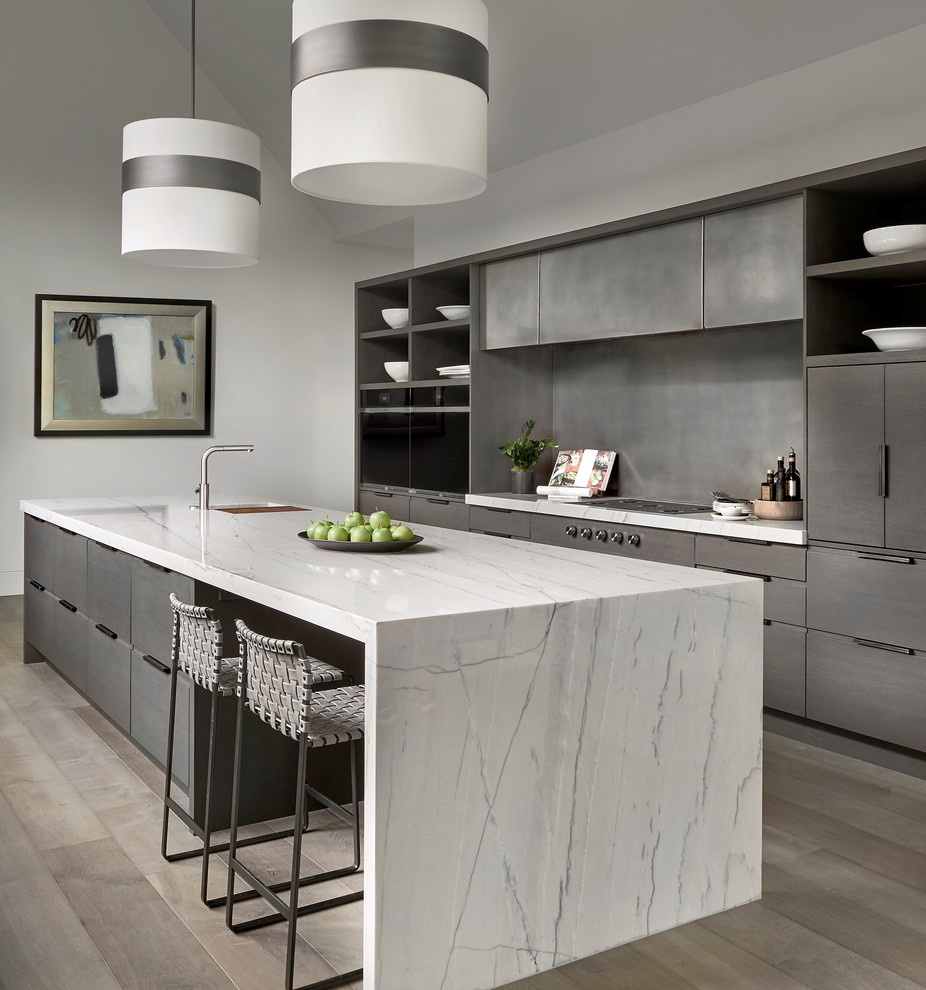 Immagine di una cucina minimal con ante lisce, ante grigie, paraspruzzi grigio, elettrodomestici neri, pavimento marrone e top grigio