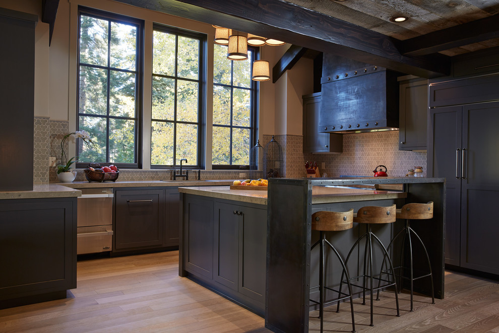 Пример оригинального дизайна: п-образная кухня-гостиная в стиле рустика с фасадами в стиле шейкер, синими фасадами и техникой под мебельный фасад