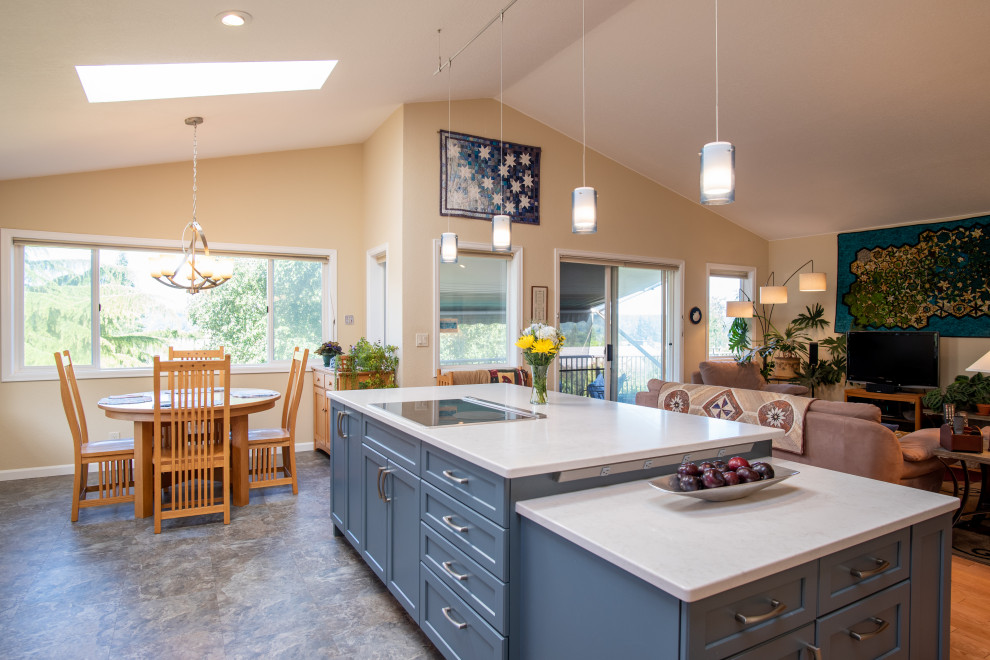 Example of a mid-sized transitional l-shaped vinyl floor, blue floor and vaulted ceiling open concept kitchen design in Seattle with an undermount sink, recessed-panel cabinets, blue cabinets, quartz countertops, blue backsplash, ceramic backsplash, stainless steel appliances, an island and gray countertops