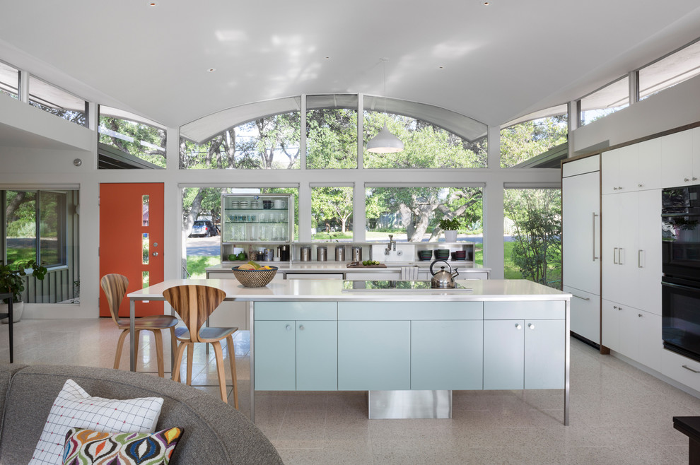 Идея дизайна: угловая кухня-гостиная среднего размера в стиле ретро с врезной мойкой, плоскими фасадами, белыми фасадами, техникой под мебельный фасад, островом, полом из терраццо и окном