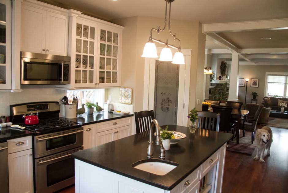 Exempel på ett mellanstort klassiskt kök, med en undermonterad diskho, luckor med glaspanel, vita skåp, granitbänkskiva, vitt stänkskydd, stänkskydd i glaskakel, rostfria vitvaror, mörkt trägolv och en köksö