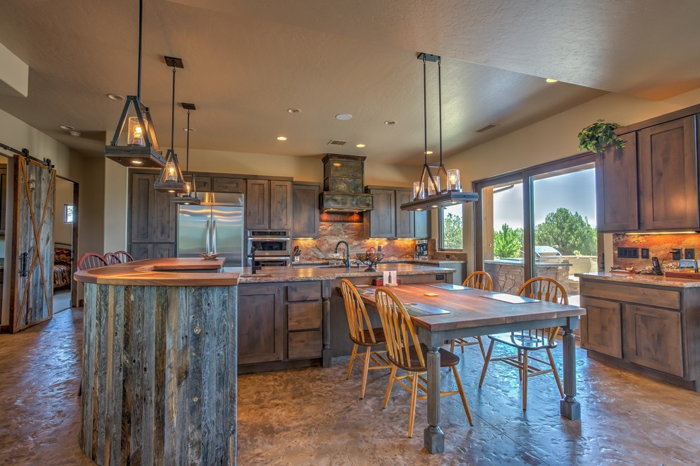 Large mountain style galley concrete floor eat-in kitchen photo in Phoenix with a triple-bowl sink, shaker cabinets, gray cabinets, brown backsplash, stone slab backsplash, stainless steel appliances, two islands and wood countertops