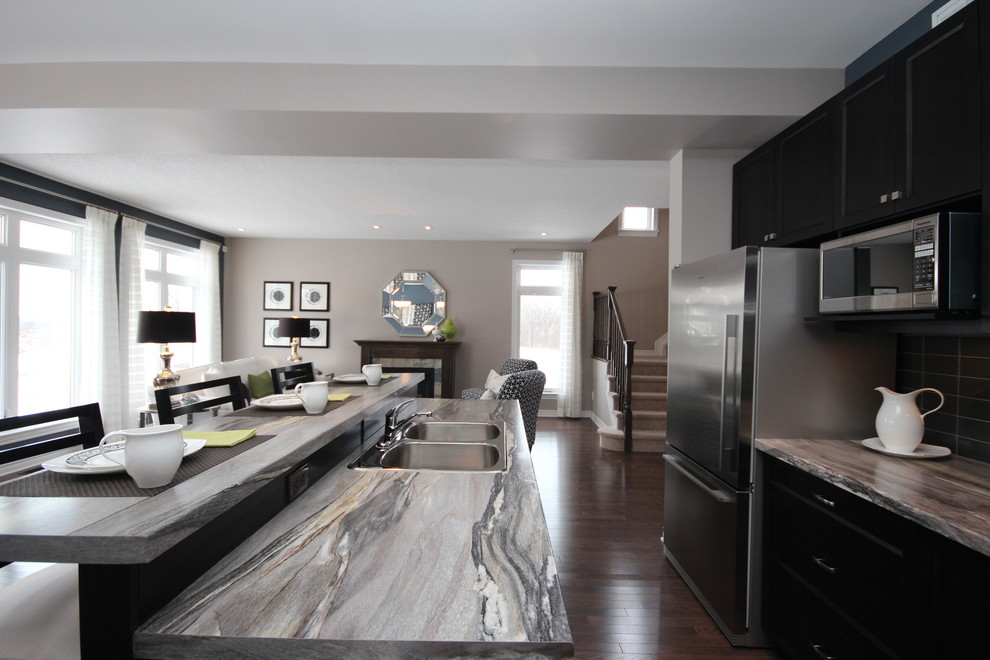 Inspiration for a medium sized contemporary l-shaped open plan kitchen in Ottawa with an island, recessed-panel cabinets, black cabinets, laminate countertops, a double-bowl sink, grey splashback, ceramic splashback, stainless steel appliances, dark hardwood flooring and brown floors.