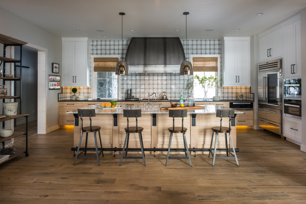Klassische Küche mit Schrankfronten im Shaker-Stil, weißen Schränken, bunter Rückwand, Küchengeräten aus Edelstahl, braunem Holzboden und Kücheninsel in Minneapolis
