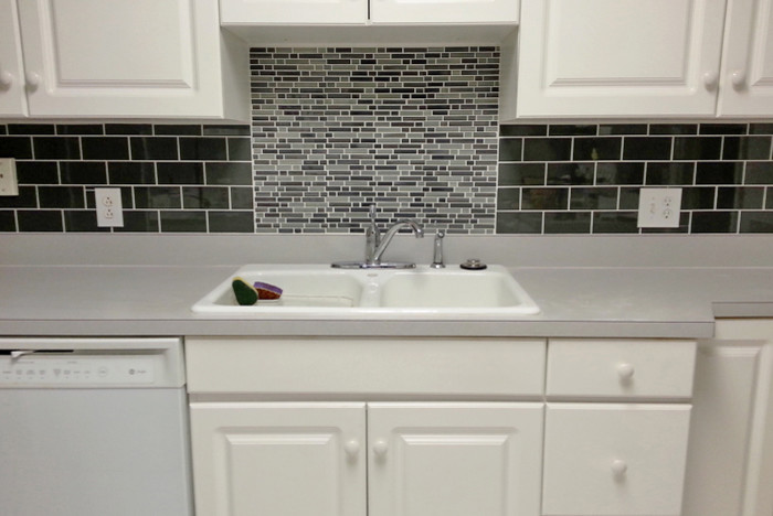 Immagine di una cucina chic con lavello a doppia vasca, ante con bugna sagomata, ante bianche, top in superficie solida, paraspruzzi multicolore, paraspruzzi in gres porcellanato e elettrodomestici bianchi