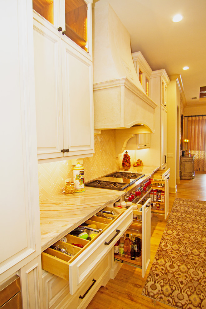 Inspiration för ett mycket stort medelhavsstil kök, med en undermonterad diskho, luckor med upphöjd panel, vita skåp, granitbänkskiva, vitt stänkskydd, stänkskydd i stenkakel, integrerade vitvaror, mellanmörkt trägolv, en köksö och brunt golv