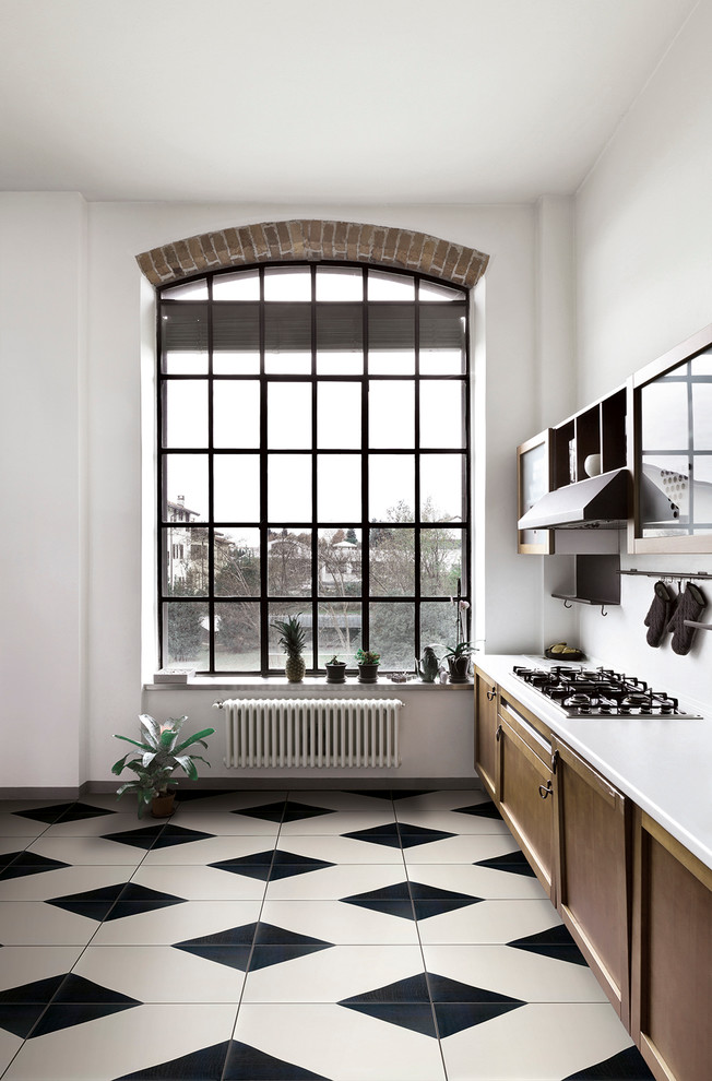 Cette photo montre une cuisine linéaire chic en bois brun avec un placard avec porte à panneau encastré, un plan de travail en surface solide, une crédence blanche et un sol en carrelage de céramique.