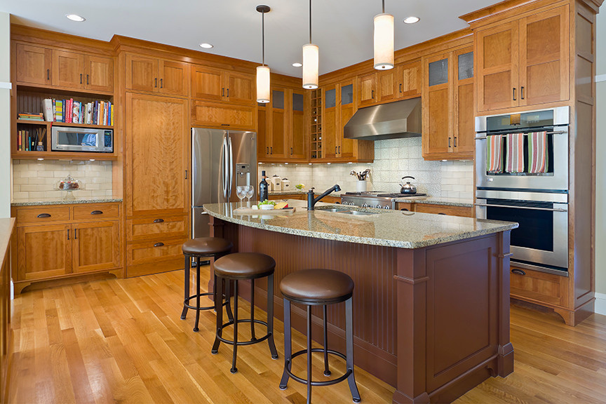 Inspiration for a mid-sized timeless l-shaped light wood floor kitchen remodel in Minneapolis with a single-bowl sink, shaker cabinets, light wood cabinets, granite countertops, white backsplash, subway tile backsplash, stainless steel appliances and an island