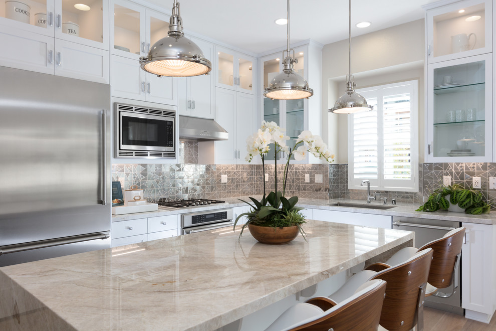 Design ideas for a traditional l-shaped open plan kitchen in San Francisco with shaker cabinets, white cabinets, an island, a submerged sink, stainless steel appliances, light hardwood flooring and metallic splashback.