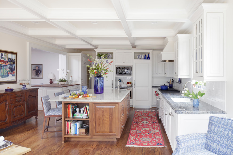Exempel på ett stort klassiskt kök, med en dubbel diskho, luckor med upphöjd panel, skåp i mellenmörkt trä, marmorbänkskiva, vitt stänkskydd, stänkskydd i tunnelbanekakel, rostfria vitvaror, mellanmörkt trägolv och brunt golv