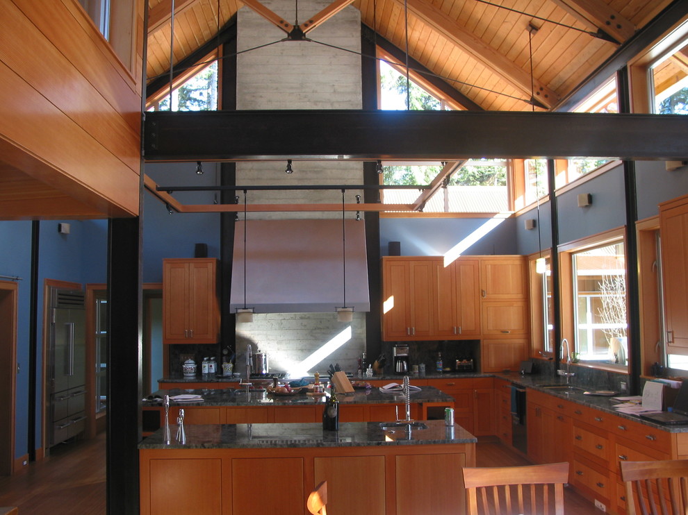 シアトルにあるインダストリアルスタイルのおしゃれなキッチン (シェーカースタイル扉のキャビネット、中間色木目調キャビネット、御影石カウンター) の写真