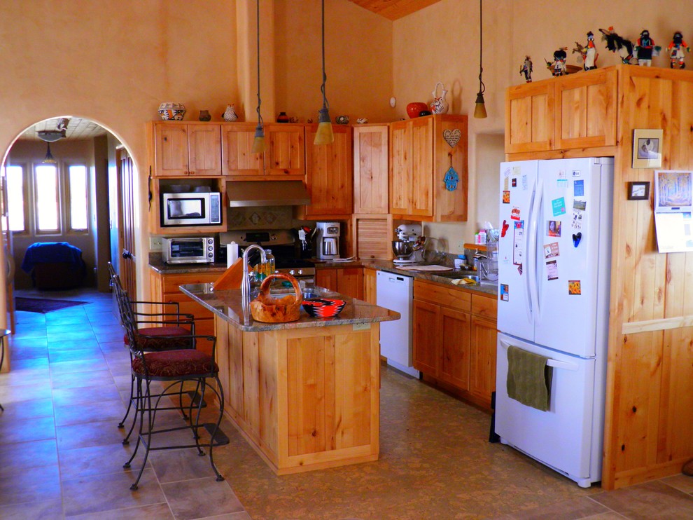 Inspiration for a mid-sized southwestern l-shaped travertine floor eat-in kitchen remodel in Albuquerque with an undermount sink, recessed-panel cabinets, medium tone wood cabinets, granite countertops, white appliances and an island