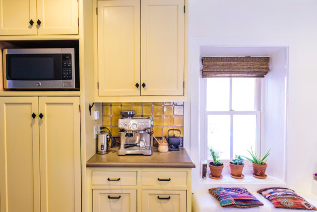 Enclosed kitchen - mid-sized traditional u-shaped dark wood floor and brown floor enclosed kitchen idea in Albuquerque with a farmhouse sink, shaker cabinets, yellow cabinets, concrete countertops, yellow backsplash, ceramic backsplash, stainless steel appliances and an island