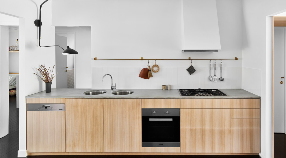 Foto di una piccola cucina parallela contemporanea con ante in legno chiaro, top in cemento, parquet scuro e pavimento nero