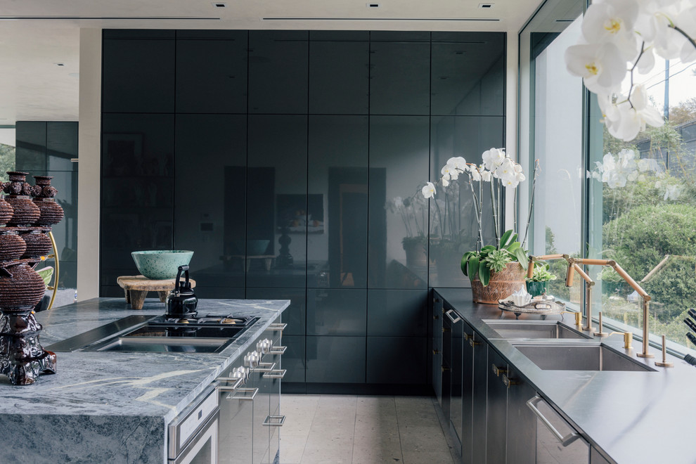 Zweizeilige Moderne Küche mit Unterbauwaschbecken, flächenbündigen Schrankfronten, Kücheninsel, Kalkstein-Arbeitsplatte, Küchengeräten aus Edelstahl, Porzellan-Bodenfliesen und grauem Boden in New York