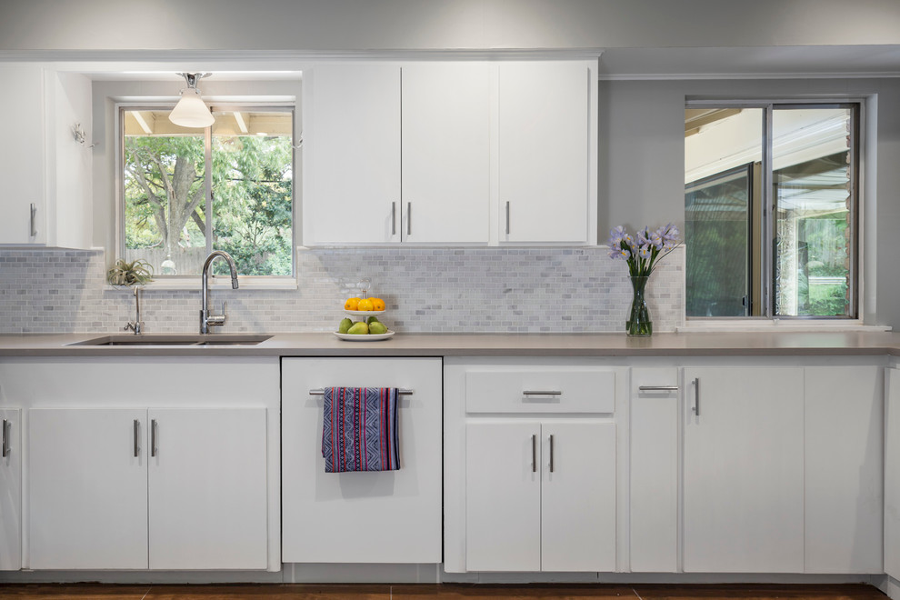 Example of a mid-sized 1950s u-shaped porcelain tile eat-in kitchen design in Austin with an undermount sink, flat-panel cabinets, white cabinets, quartz countertops, yellow backsplash, stone tile backsplash, paneled appliances and a peninsula