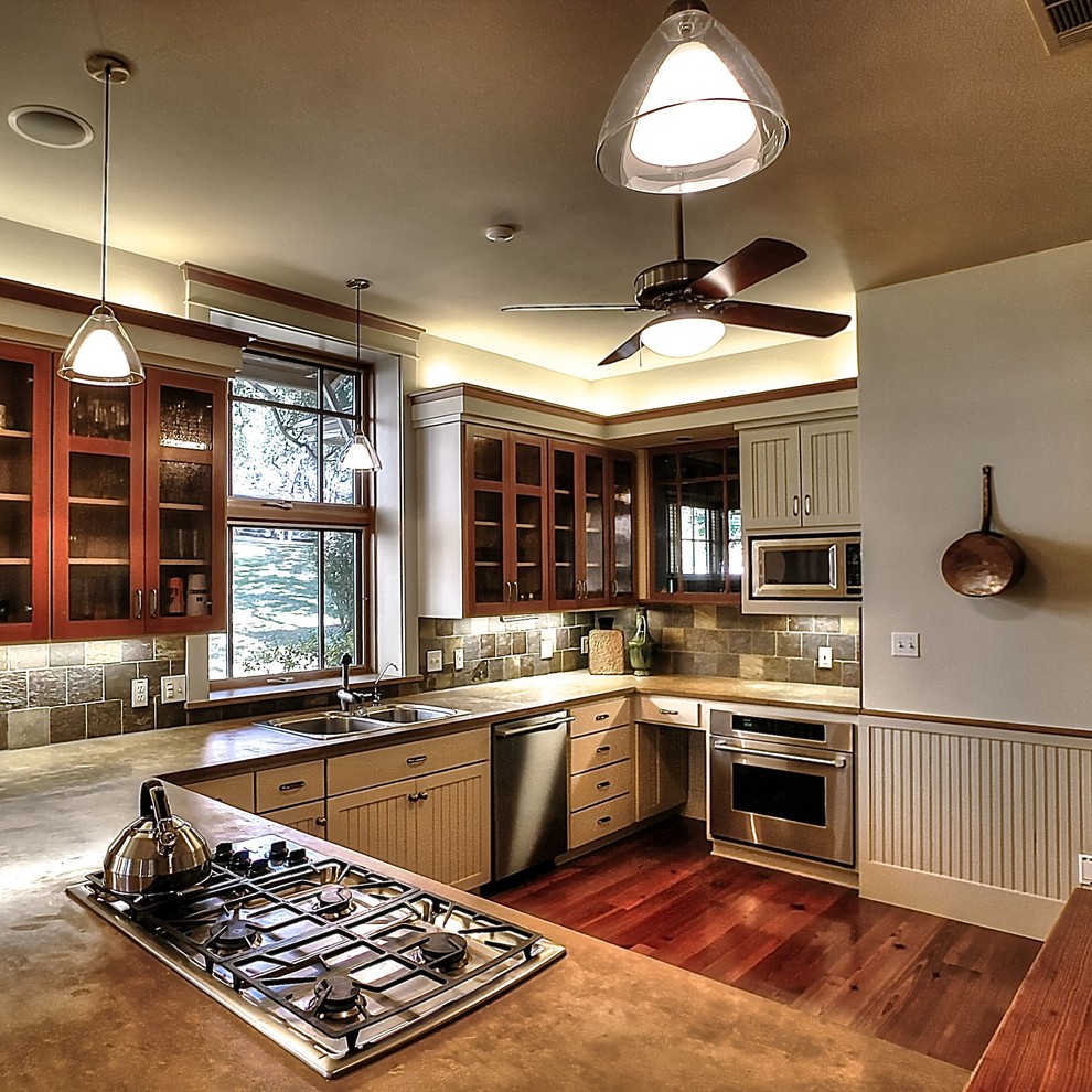 Cette image montre une grande cuisine ouverte minimaliste en U et bois brun avec un évier 2 bacs, un placard à porte vitrée, une crédence multicolore, un électroménager en acier inoxydable et un sol en bois brun.