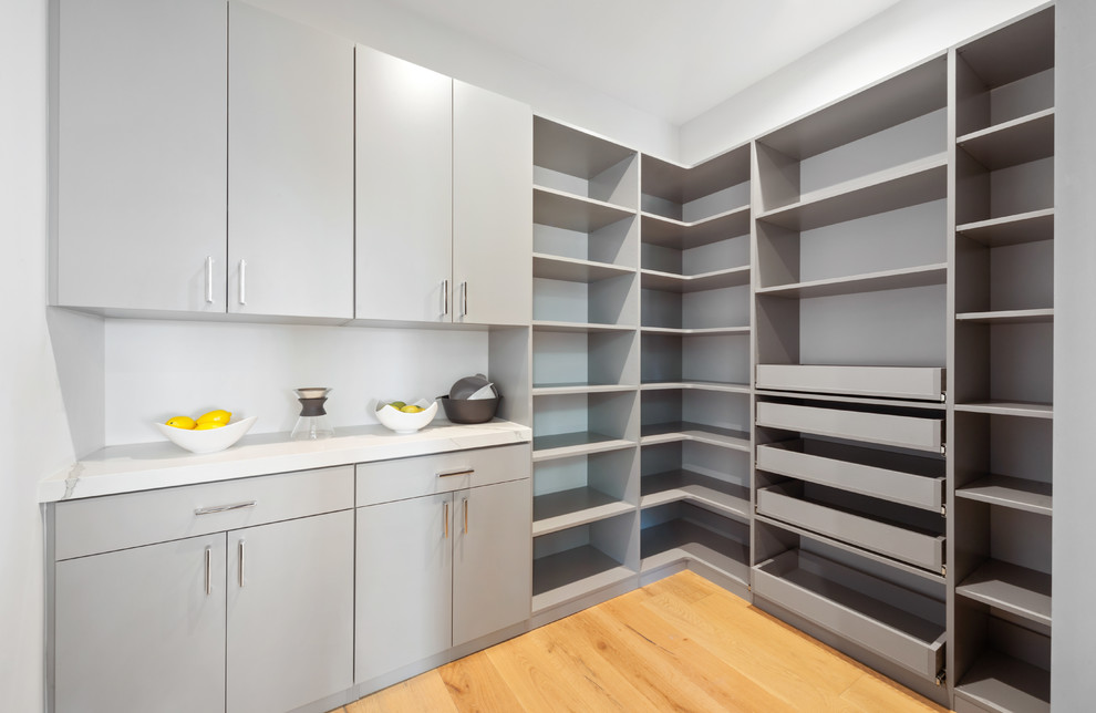 Photo of a large contemporary u-shaped kitchen pantry in Los Angeles with open cabinets, engineered stone countertops, light hardwood flooring and white worktops.