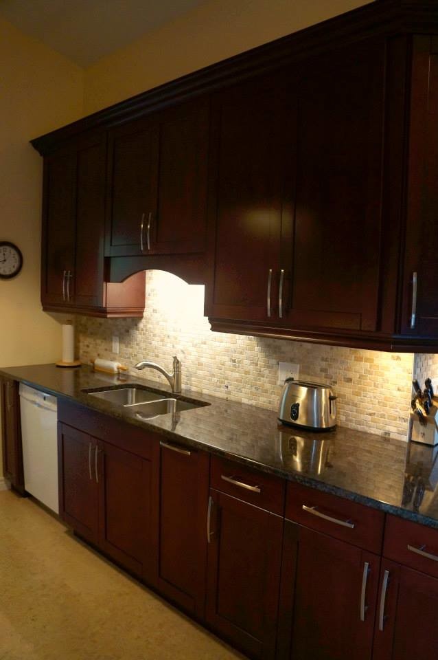 Exempel på ett klassiskt kök, med en undermonterad diskho, skåp i shakerstil, röda skåp, granitbänkskiva, beige stänkskydd, stänkskydd i stenkakel, vita vitvaror och korkgolv