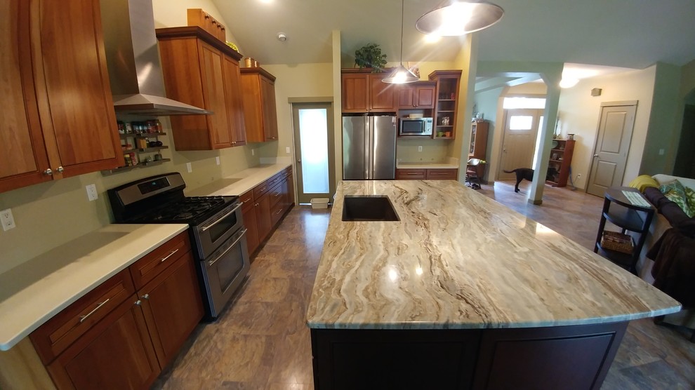 Large elegant l-shaped laminate floor and brown floor enclosed kitchen photo in Seattle with quartz countertops, stone slab backsplash, an island, an undermount sink, raised-panel cabinets, medium tone wood cabinets and stainless steel appliances