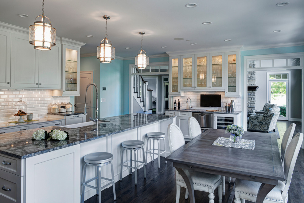 Inspiration for a large transitional dark wood floor eat-in kitchen remodel in Chicago with white cabinets, marble countertops, stainless steel appliances, an island, a farmhouse sink, shaker cabinets, white backsplash and subway tile backsplash