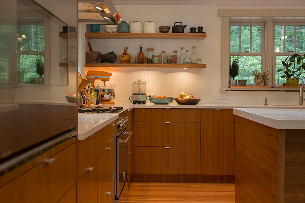Modelo de cocina actual con armarios estilo shaker, puertas de armario de madera en tonos medios, encimera de acrílico y electrodomésticos de acero inoxidable