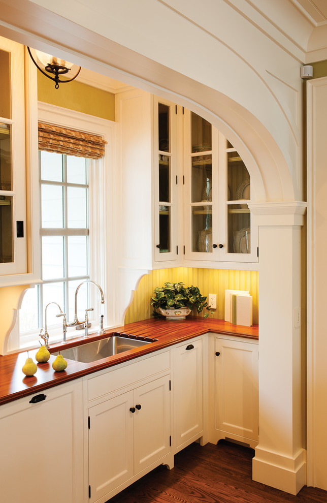 Example of a classic kitchen design in Atlanta with an undermount sink, beaded inset cabinets, white cabinets, wood countertops and yellow backsplash
