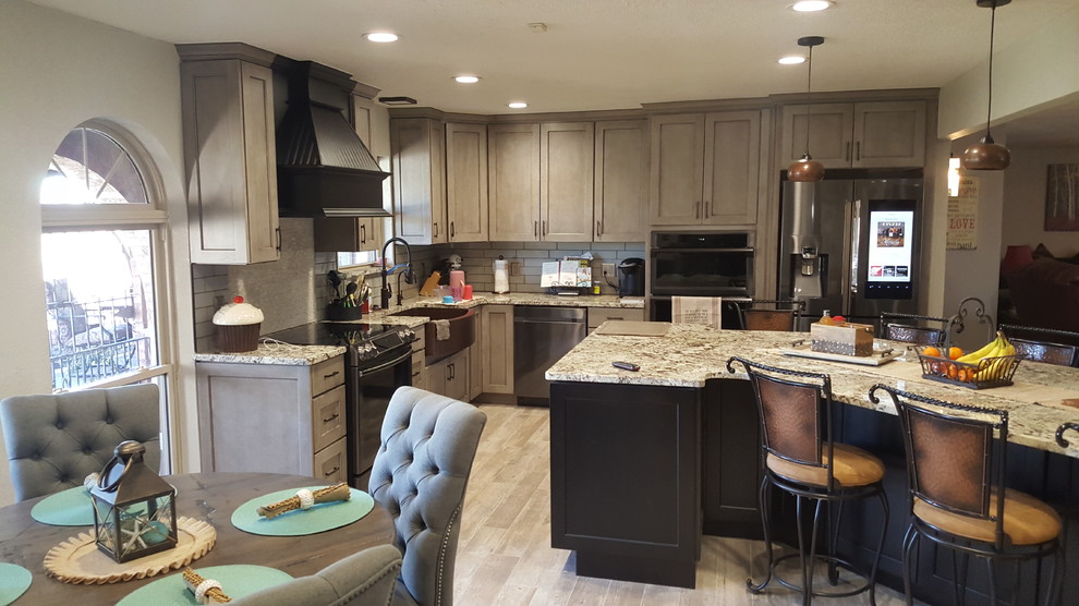 Mid-sized elegant porcelain tile eat-in kitchen photo in Oklahoma City with a farmhouse sink, shaker cabinets, granite countertops, glass tile backsplash and an island
