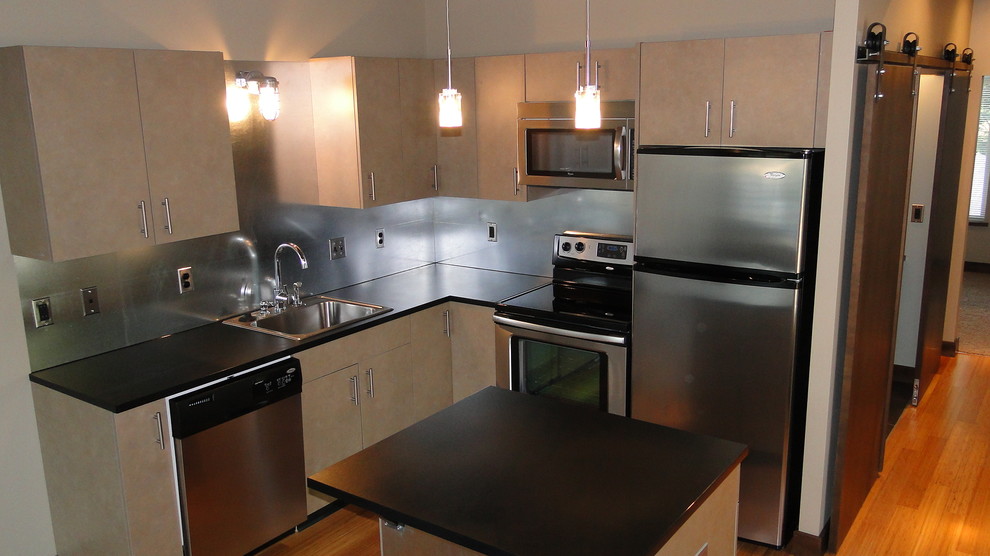 Small urban l-shaped kitchen photo in Other with a single-bowl sink, flat-panel cabinets, metal backsplash, stainless steel appliances and an island