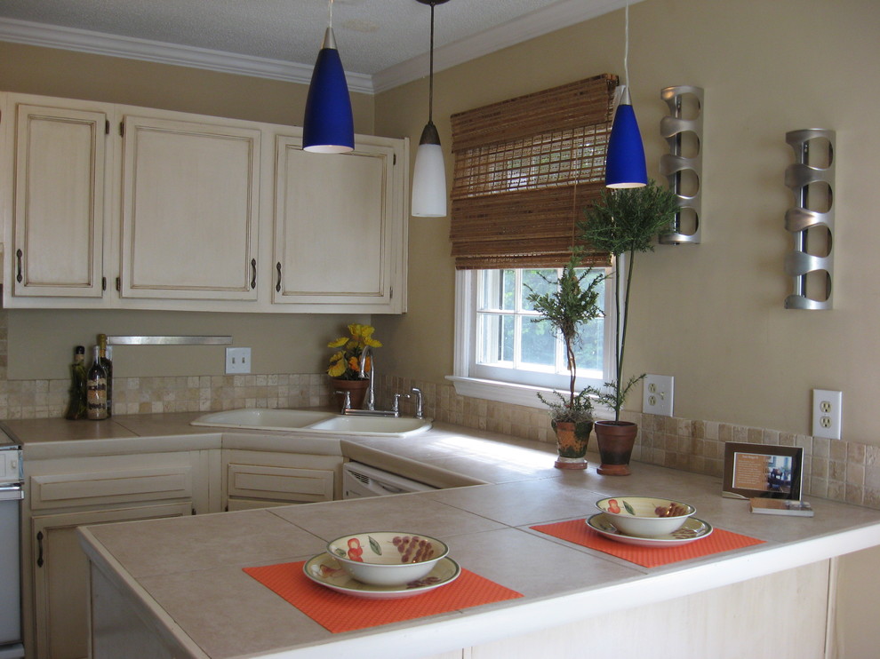 Elegant kitchen photo in Charlotte with tile countertops, beige backsplash and stone tile backsplash