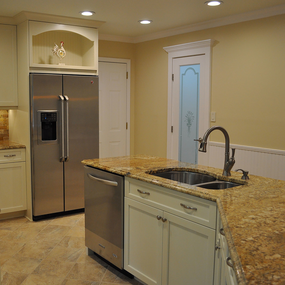 Exempel på ett klassiskt kök med öppen planlösning, med en undermonterad diskho, luckor med infälld panel, vita skåp, granitbänkskiva, flerfärgad stänkskydd, stänkskydd i stenkakel, rostfria vitvaror, klinkergolv i porslin och en köksö