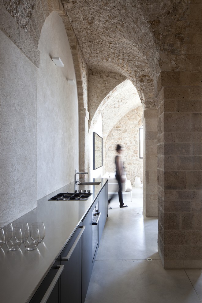 Свежая идея для дизайна: прямая кухня в средиземноморском стиле с плоскими фасадами и черными фасадами - отличное фото интерьера