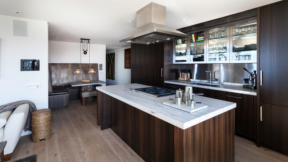 Cette image montre une cuisine design avec un placard à porte plane, plan de travail en marbre et une crédence en dalle métallique.