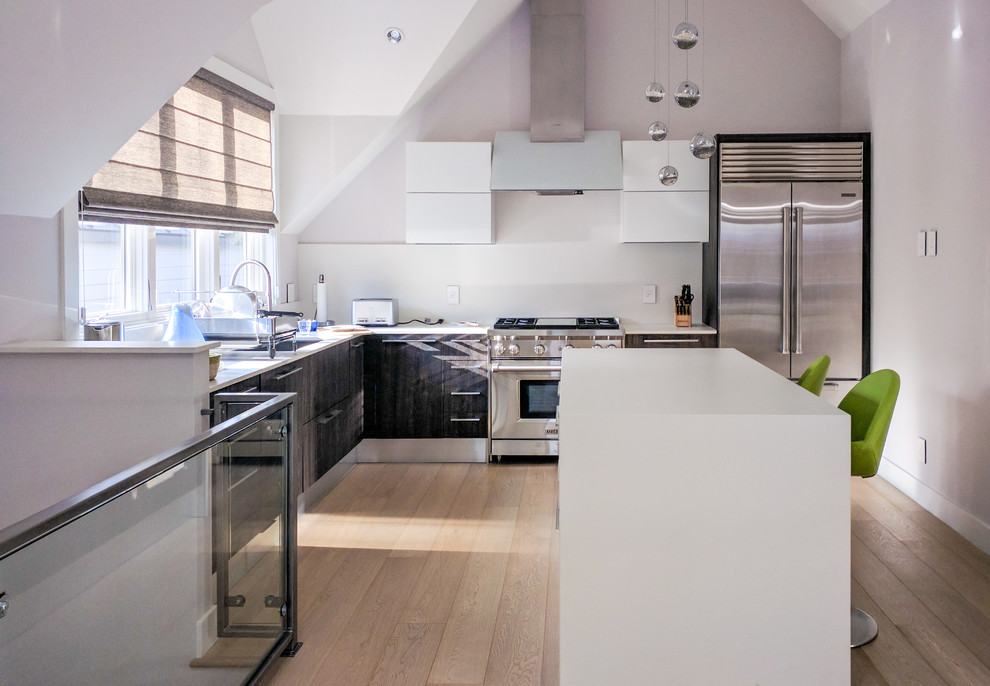 Exempel på ett modernt l-kök, med vitt stänkskydd, rostfria vitvaror, ljust trägolv, en köksö, släta luckor och vita skåp