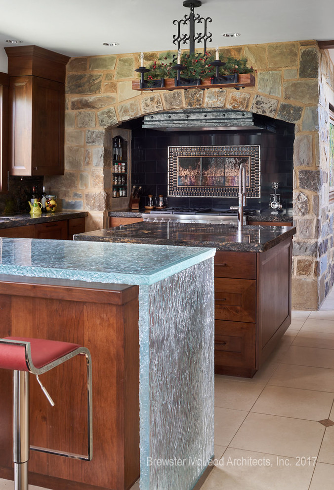 Immagine di un cucina con isola centrale rustico con ante in legno scuro, top in granito, elettrodomestici in acciaio inossidabile e pavimento beige
