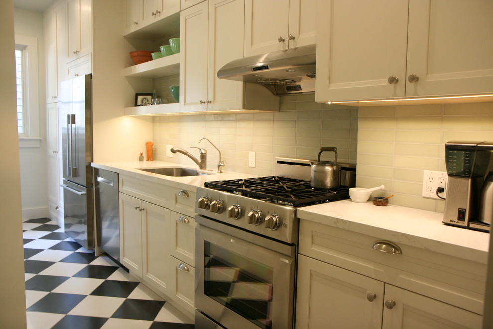 Foto på ett litet vintage kök, med luckor med infälld panel, vita skåp, bänkskiva i kvartsit, stänkskydd i keramik, rostfria vitvaror och klinkergolv i porslin