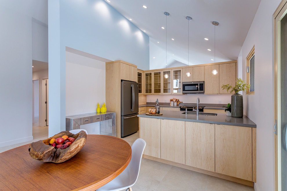 This is an example of a traditional l-shaped kitchen in Phoenix with a submerged sink, flat-panel cabinets, light wood cabinets, engineered stone countertops, grey splashback, porcelain flooring, a breakfast bar and beige floors.
