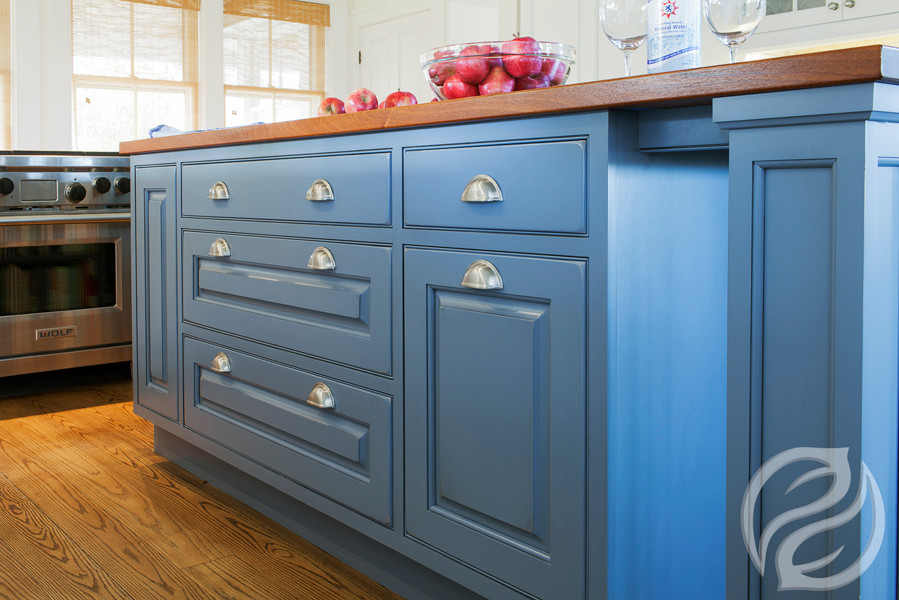 Foto di un cucina con isola centrale country con ante con bugna sagomata, ante blu, top in legno, pavimento in legno massello medio e pavimento marrone